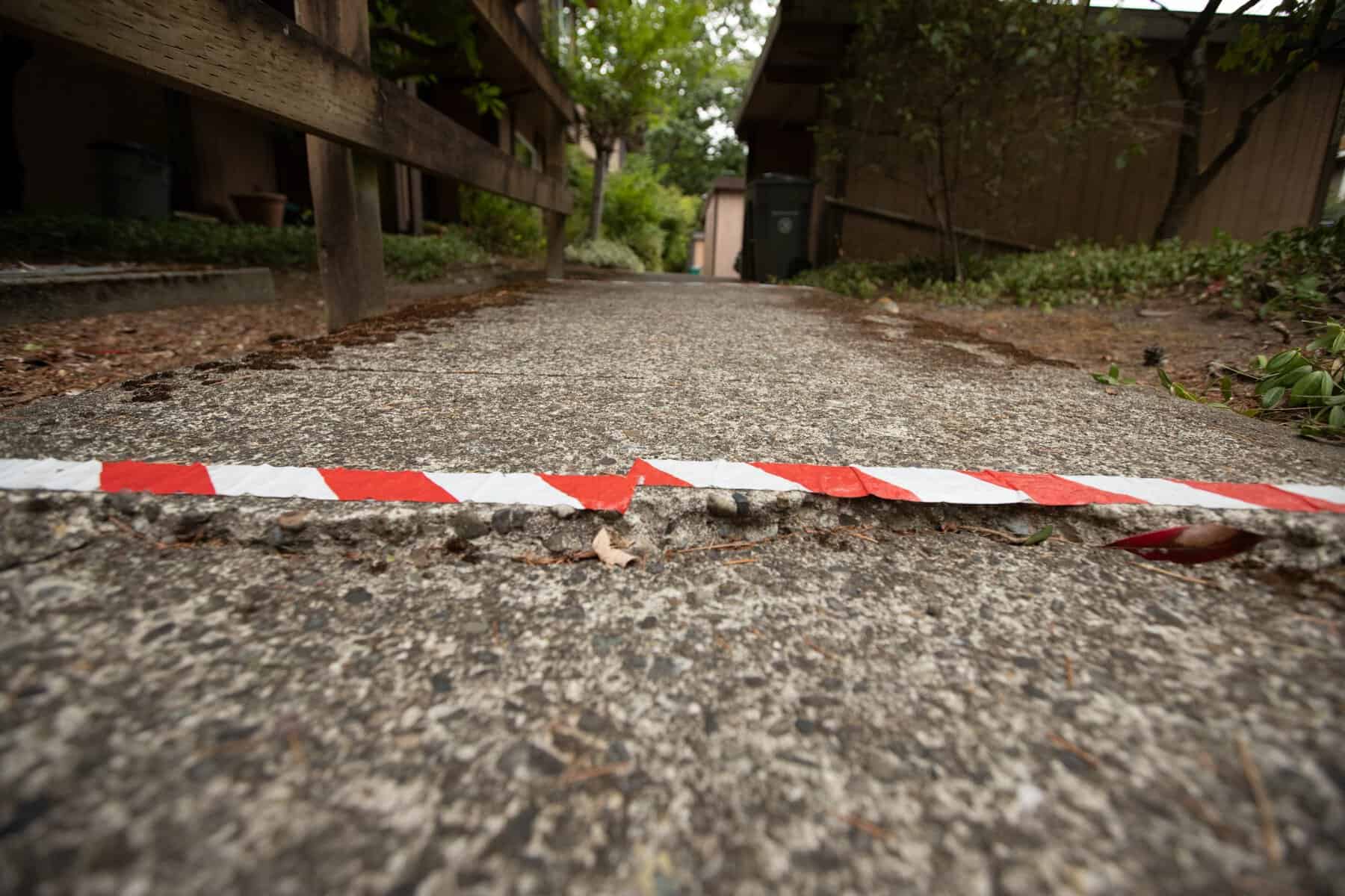 Image of sunken concrete with caution tape on it. 