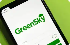 A smartphone screen displays the GreenSky app login page with fields for user ID and password, and the GreenSky logo in green text on a white background, inviting users to securely access their financing plan and explore convenient finance options.